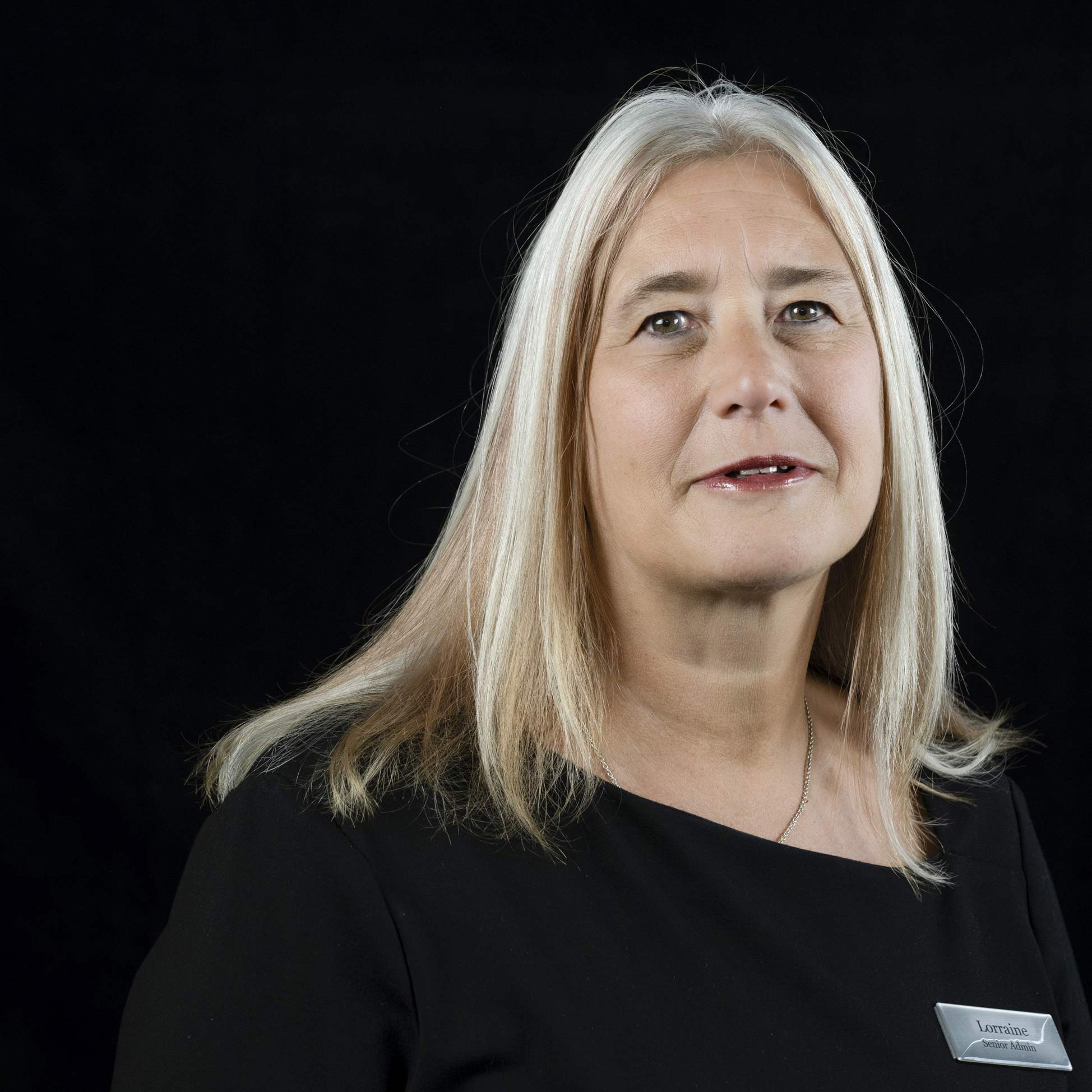 A headshot of Lorraine Verney against a black background