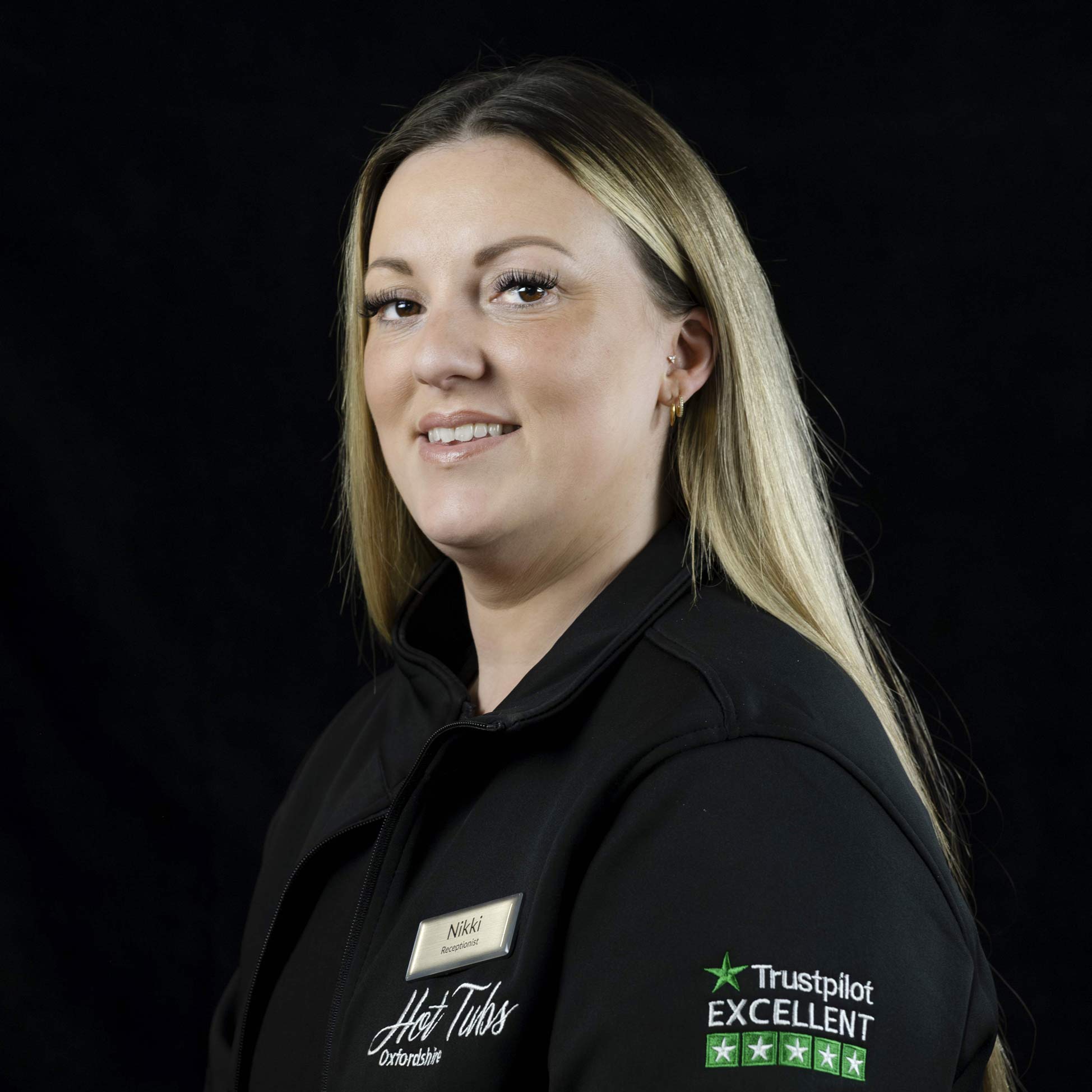 A headshot of Nikki Anderton against a black background