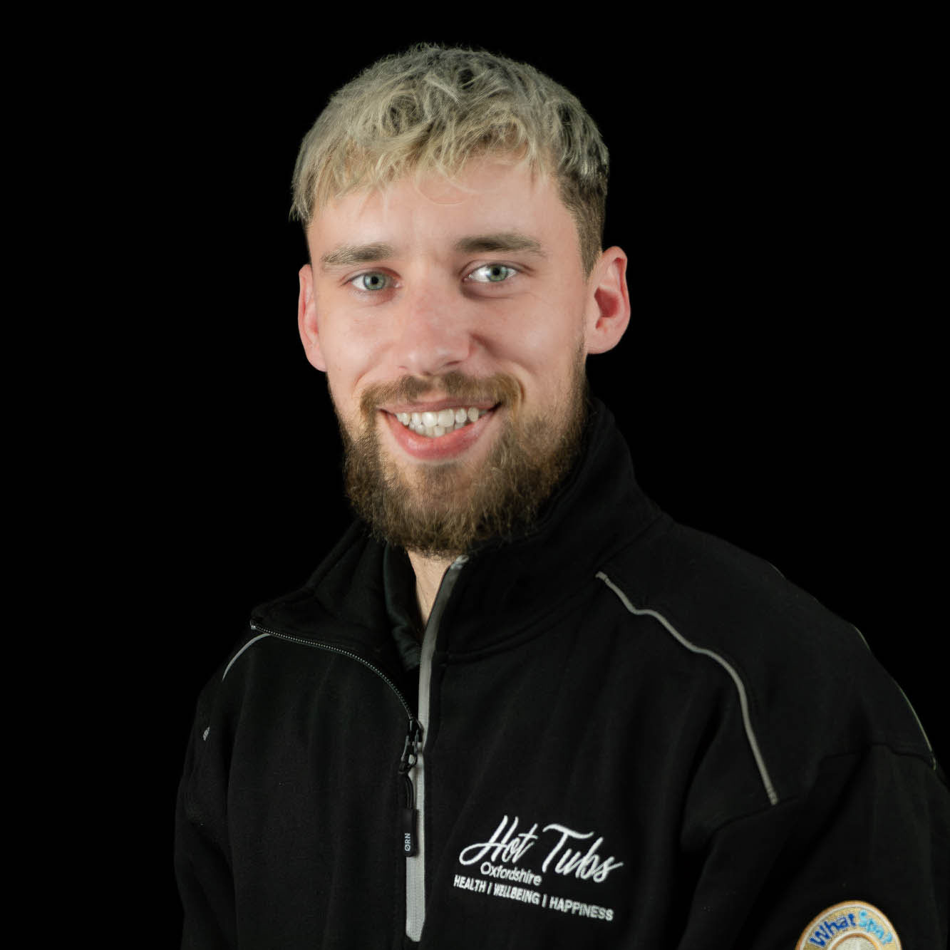 A headshot of Kieran Reynolds against a black background