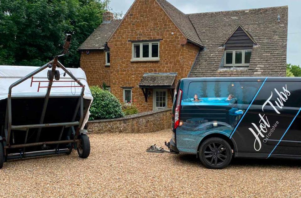 A wrapped hot tub on a specialist trailer being delivered by one of the Hot Tubs Oxfordshire vans